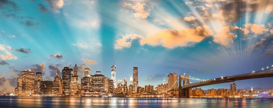 Dramatic sky over Brooklyn Bridge and Manhattan, panoramic night view of New York City