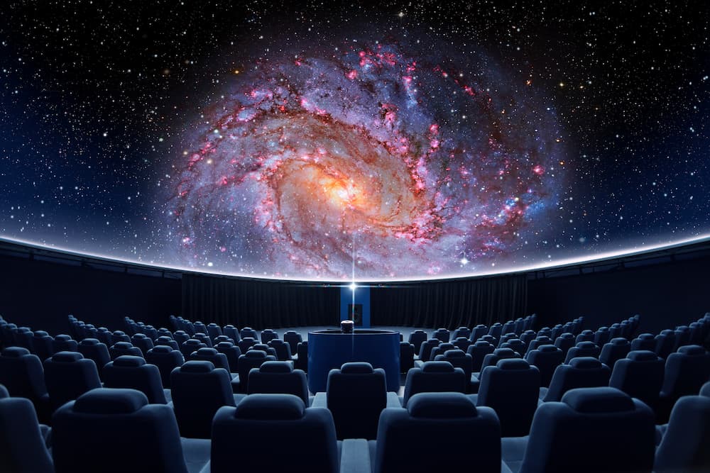 Empty planetarium displaying galaxy on screen